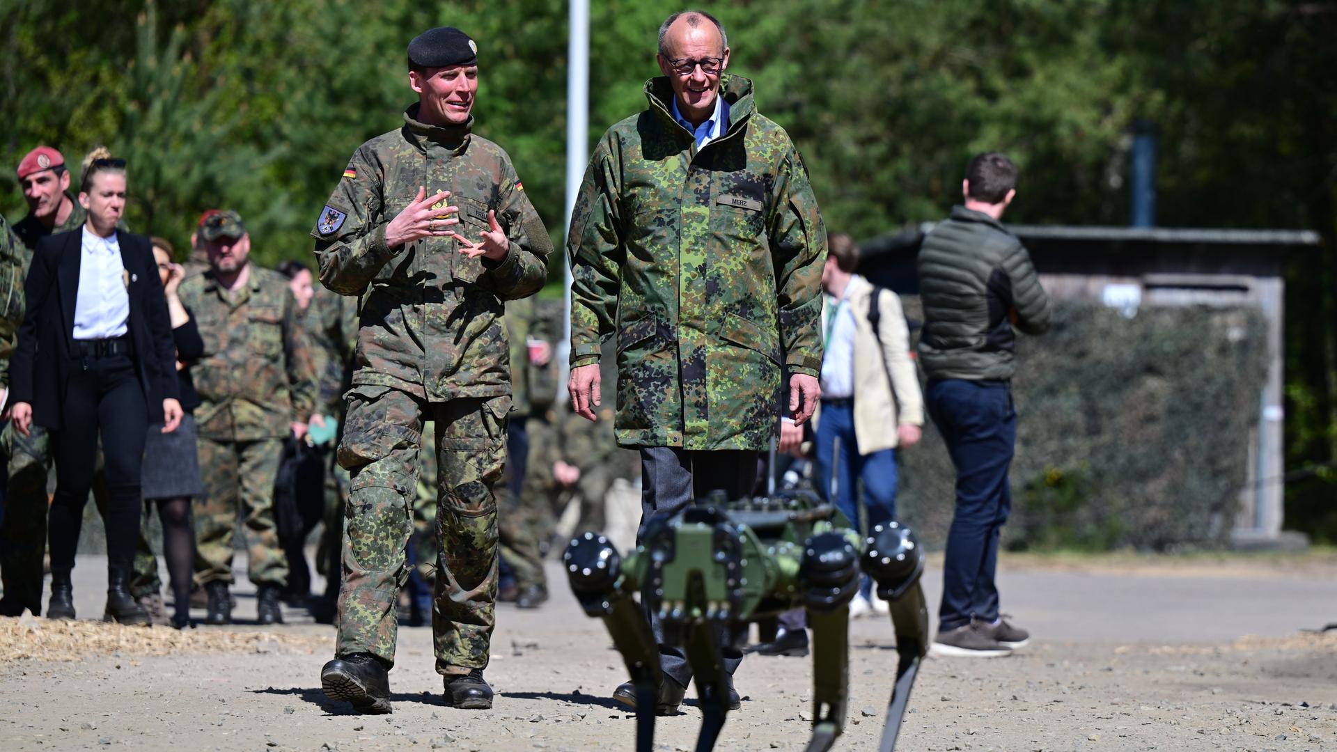 Bundeskanzler Friedrich Merz (CDU) besucht das Heer in Munster und unterhält sich mit dem Inspekteur des Heeres, Generalleutnant Christian Freuding (l). 