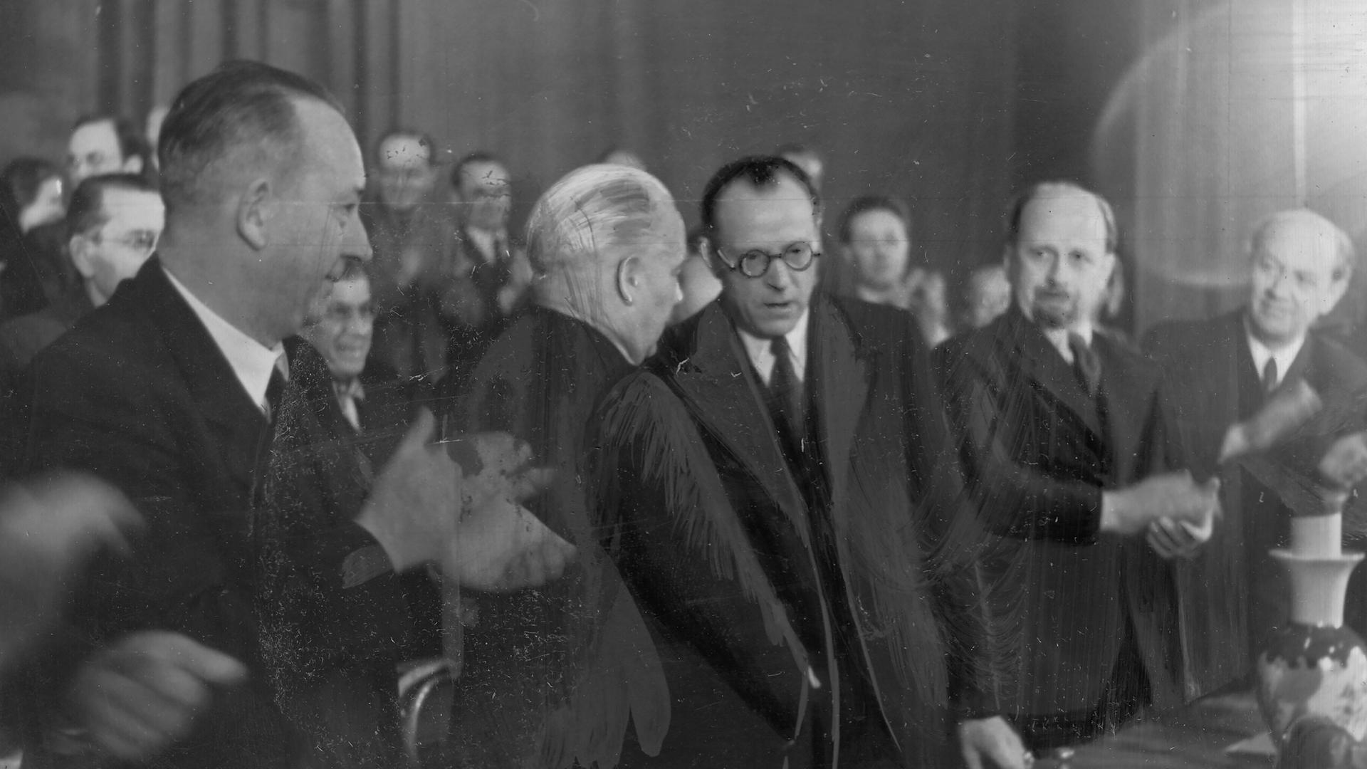 Vereinigungsparteitag der KPD und SPD zur SED am 20.04.1946 in Berlin. Symbolischer Händedruck von Wilhelm Pieck (KPD) und Otto Grotewohl (SPD). Auch auf dem Bild zu sehen: Walter Ulbricht (r.).