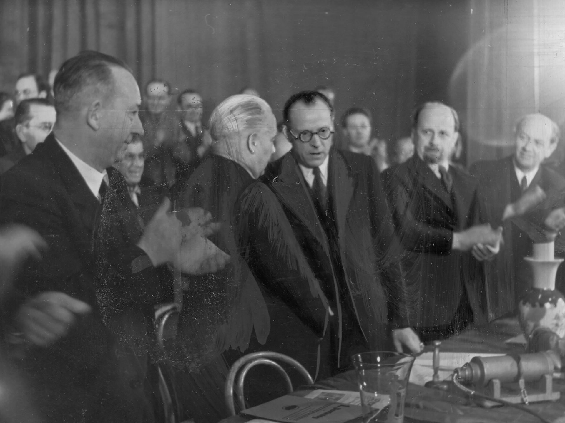 Vereinigungsparteitag der KPD und SPD zur SED am 20.04.1946 in Berlin. Symbolischer Händedruck von Wilhelm Pieck (KPD) und Otto Grotewohl (SPD). Auch auf dem Bild zu sehen: Walter Ulbricht (r.).
