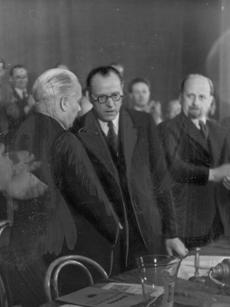 Vereinigungsparteitag der KPD und SPD zur SED am 20.04.1946 in Berlin. Symbolischer Händedruck von Wilhelm Pieck (KPD) und Otto Grotewohl (SPD). Auch auf dem Bild zu sehen: Walter Ulbricht (r.).