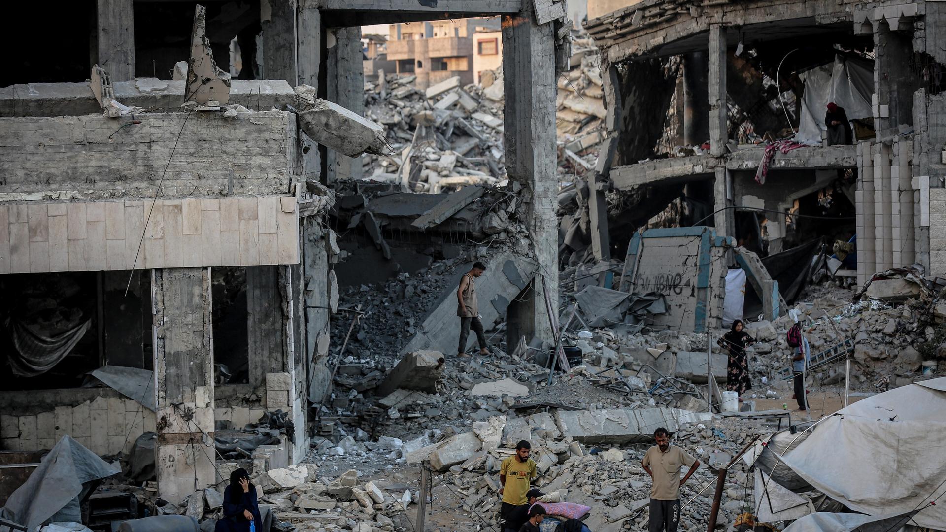 Palästinenser schauen sich ein von einem israelischen Angriff völlig zerstörtes Haus an.