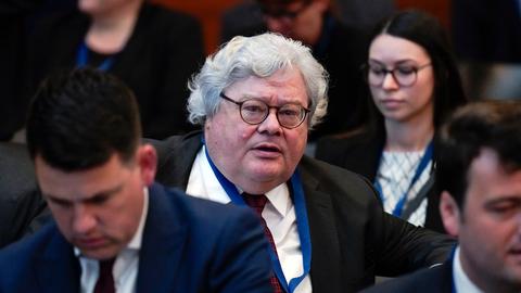 Reinhard Bütikofer bei der Europakonferenz mit dem Thema 'A larger, stronger Union: Making the European Union fit for enlargement and future members fit for accession' im Auswärtigen Amt in Berlin. Er sitzt im schwarzen Anzug mit weissem Hemd und roter Krawatte in einer Gruppe Personen und guckt in Richtung der Kamera.