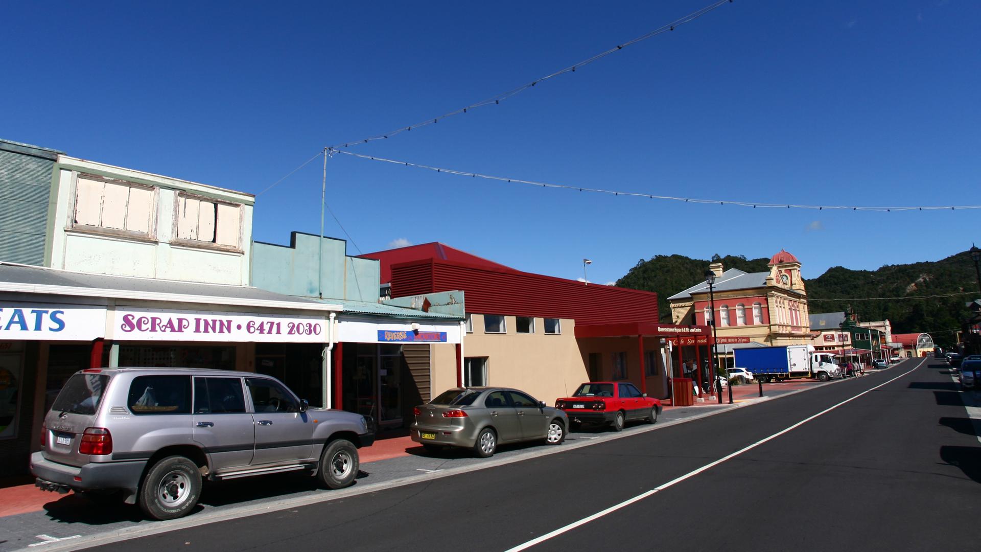 Eine Häuserfassde in der australischen Kleinstadt australische Queenstown, vor der Autos parken.