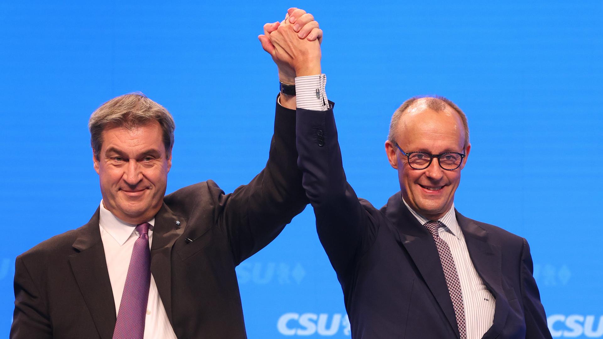 Markus Söder, CSU-Vorsitzender und bayerischer Ministerpräsident (l), steht mit Friedrich Merz,Vorsitzender der CDU, nach dessen Rede auf der Bühne.
