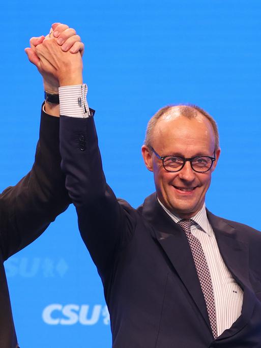 Markus Söder, CSU-Vorsitzender und bayerischer Ministerpräsident (l), steht mit Friedrich Merz,Vorsitzender der CDU, nach dessen Rede auf der Bühne.