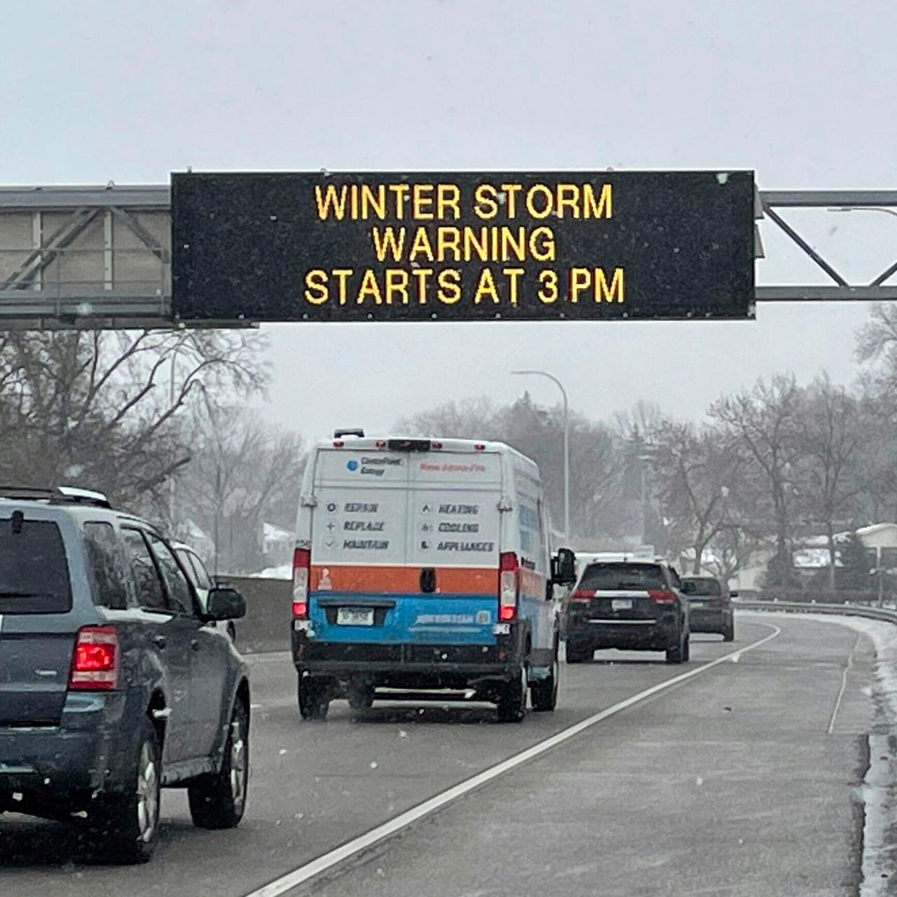 USA, Minnesota: Fahrzeuge passieren ein Schild mit der Aufschrift "WINTER STORM WARNING STARTS AT 3PM" (Wintersturmwarnung beginnt um 15 Uhr) entlang des Interstate Highway 35 in der Nähe des internationalen Flughafens Minneapolis-Saint Paul. 