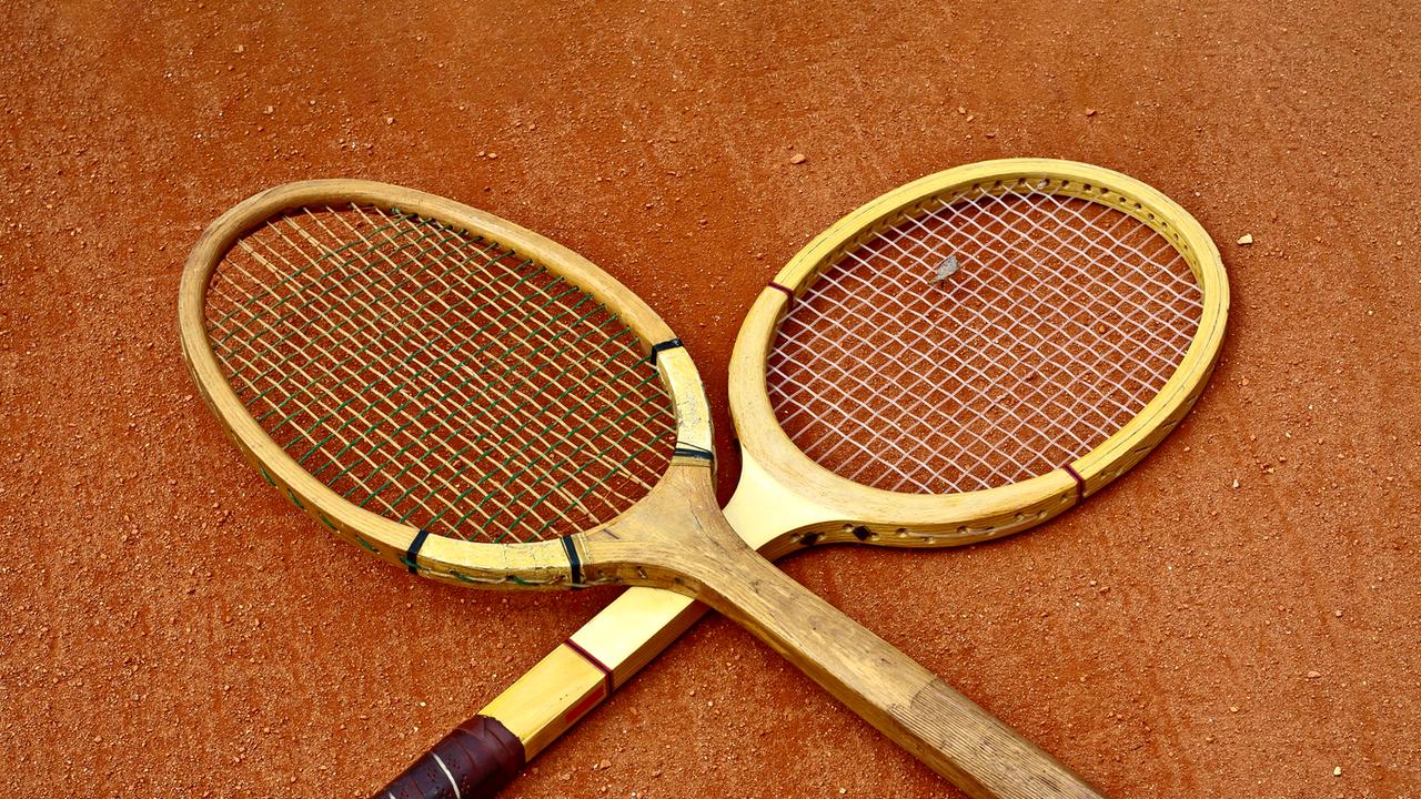 Zwei historische Tennisschläger, die überkreuzt liegen.