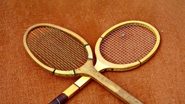 Zwei historische Tennisschläger, die überkreuzt liegen.