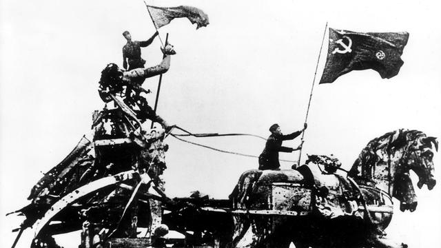 Russische Soldaten hissen die sowjetische Flagge auf dem Brandenburger Tor im Mai 1945 (historishe Aufnahme).