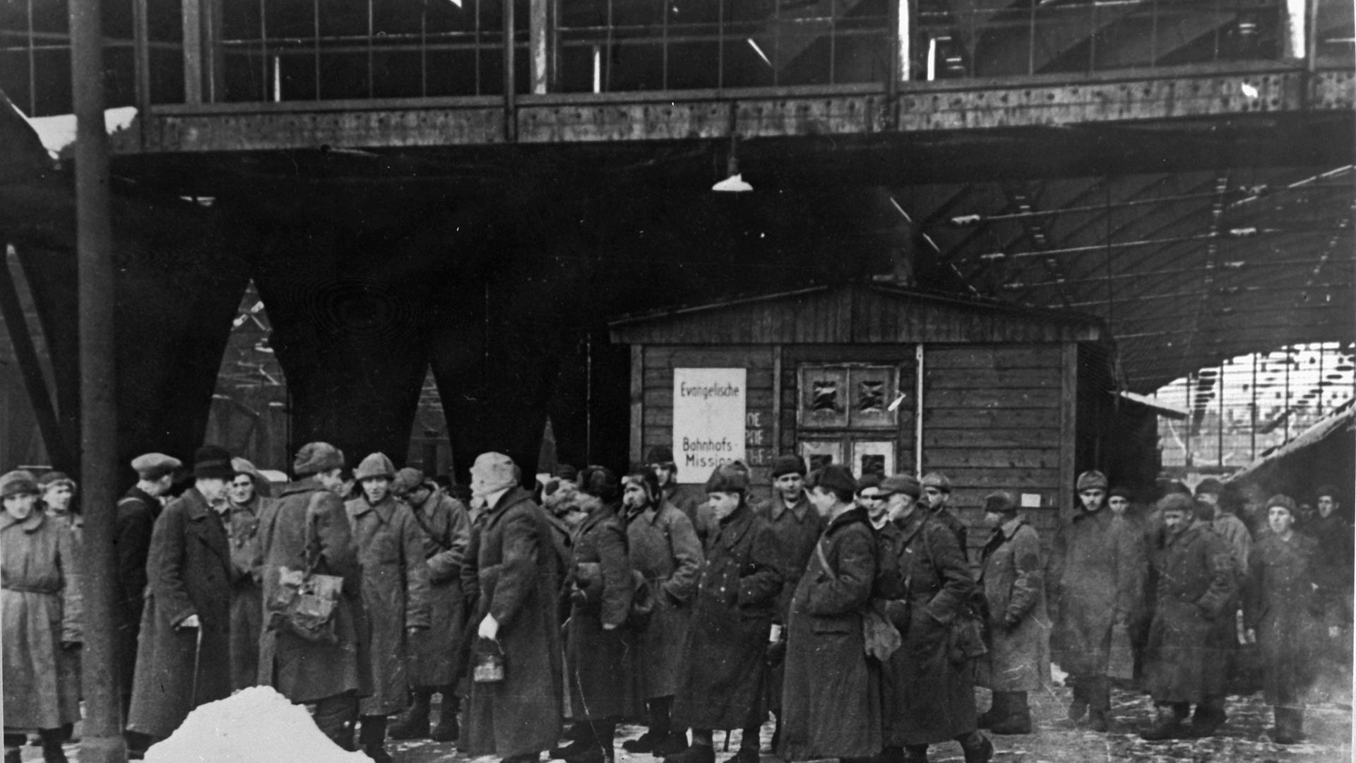Berlin-Friedrichshain, Schlesischer Bahnhof. Kriegsheimkehrer vor der Bahnhofsmission. Foto, Winter 1945/46 (Donath).