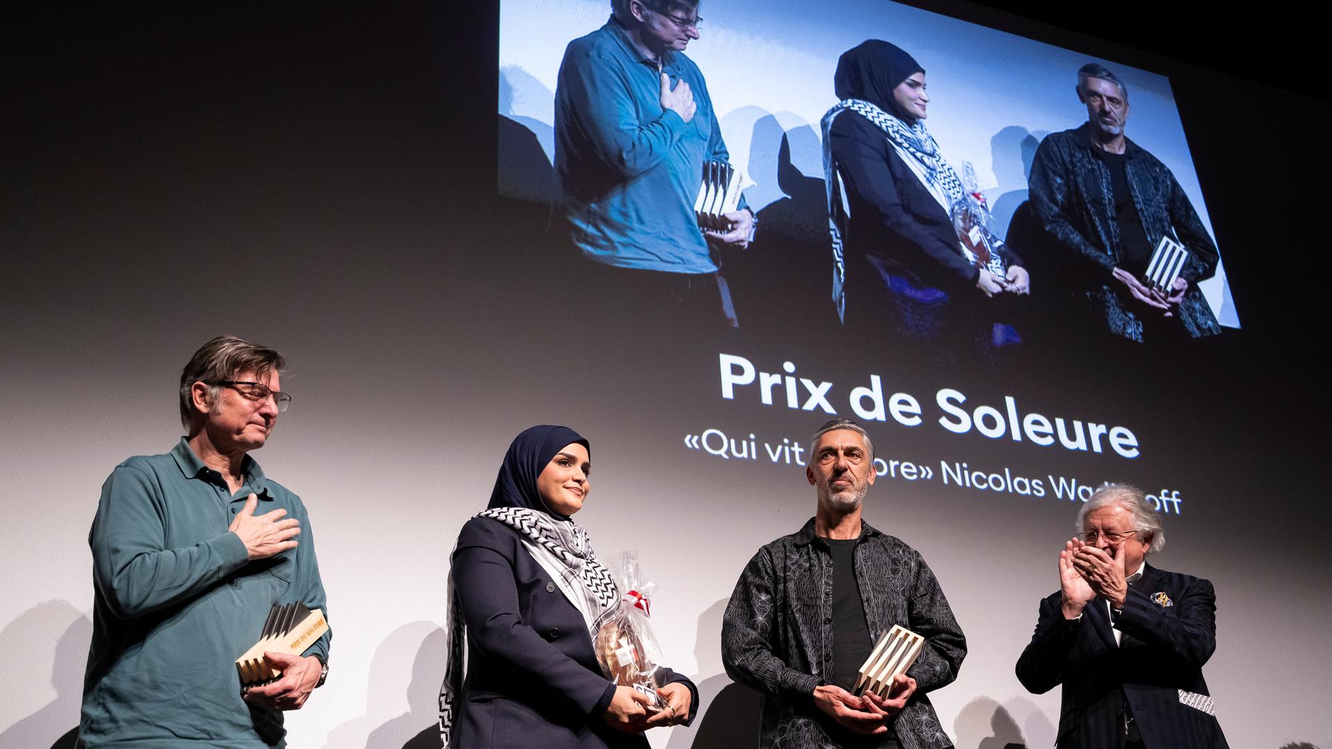 Der Regisseur Nicolas Wadimoff, Gewinner des "Prix de Soleure" mit "Qui vit encore", 2. rechts, der Produzent Philippe Coeytaux, links, die Protagonistin Haneen Harara, 2. links, waehrend der Preisverleihung der 61. Solothurner Filmtage.