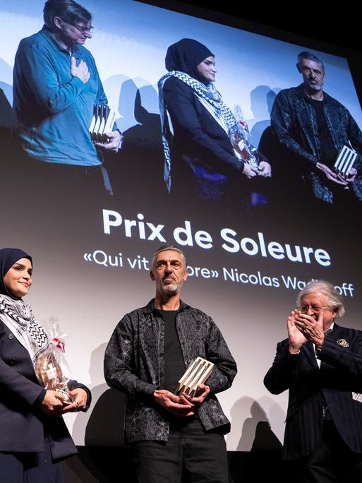 Der Regisseur Nicolas Wadimoff, Gewinner des "Prix de Soleure" mit "Qui vit encore", 2. rechts, der Produzent Philippe Coeytaux, links, die Protagonistin Haneen Harara, 2. links, waehrend der Preisverleihung der 61. Solothurner Filmtage.