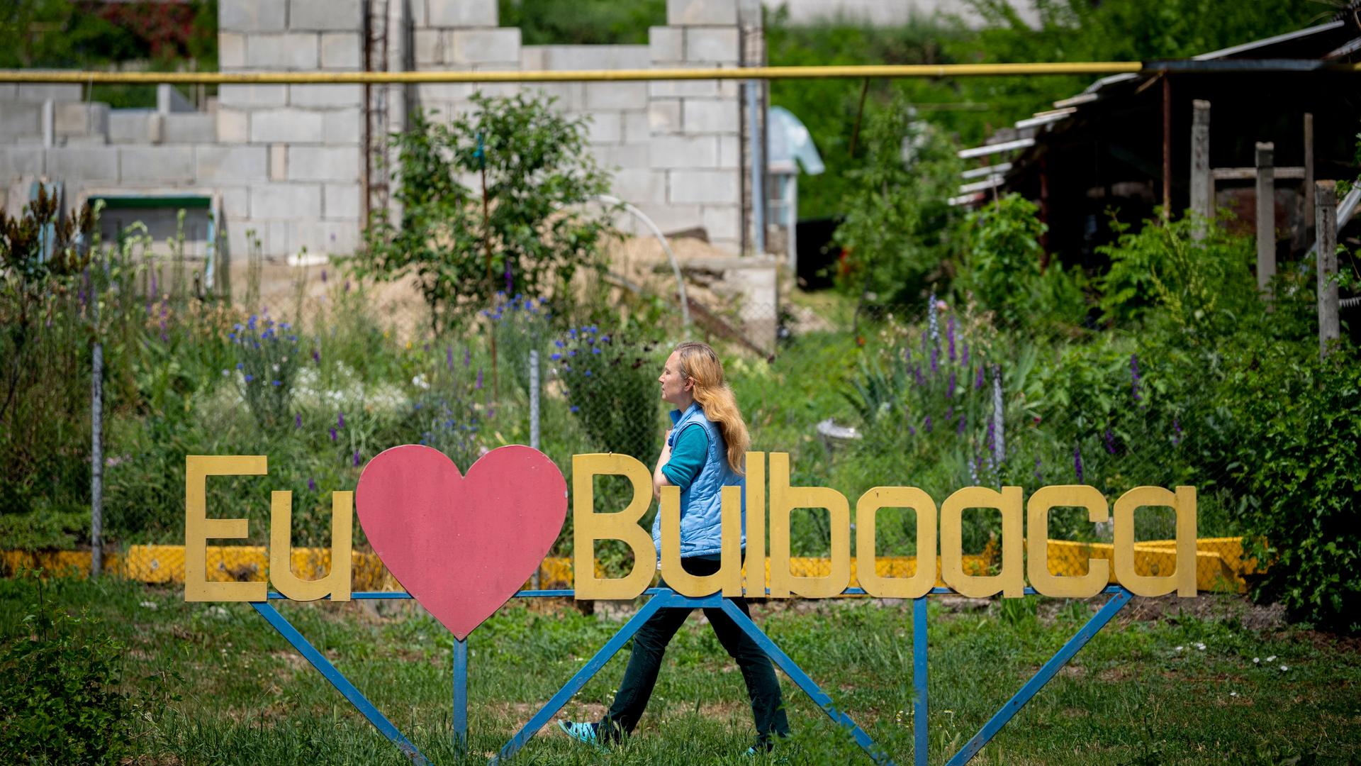 Bulboaca: Eine Frau geht an einem Schild mit der Aufschrift "Ich liebe Bulboaca" vor dem Castel Mimi vorbei.