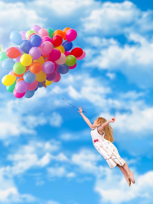 Ein Kind fliegt durch die Lüfte - getragen von einem riesigen Bündel an bunten Ballons