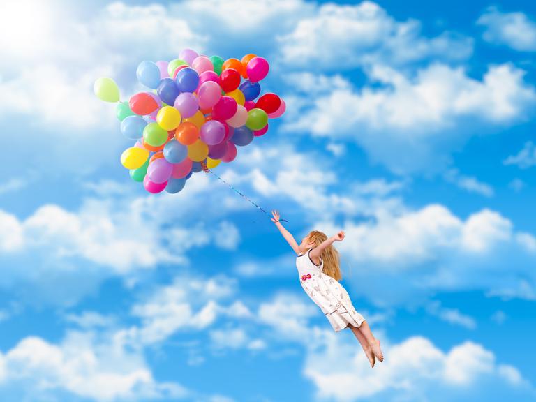 Ein Kind fliegt durch die Lüfte - getragen von einem riesigen Bündel an bunten Ballons