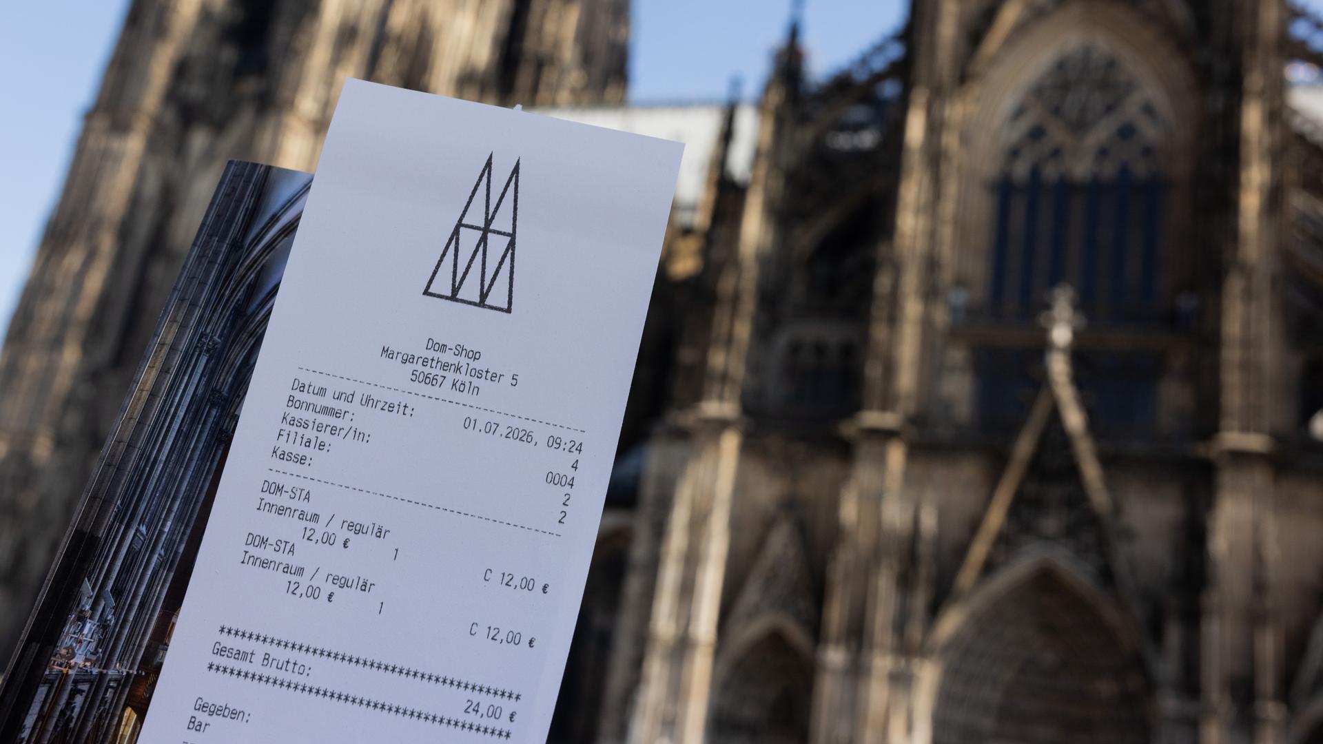 Eine Touristin zeigt ihr Ticket vor dem Kölner Dom. 