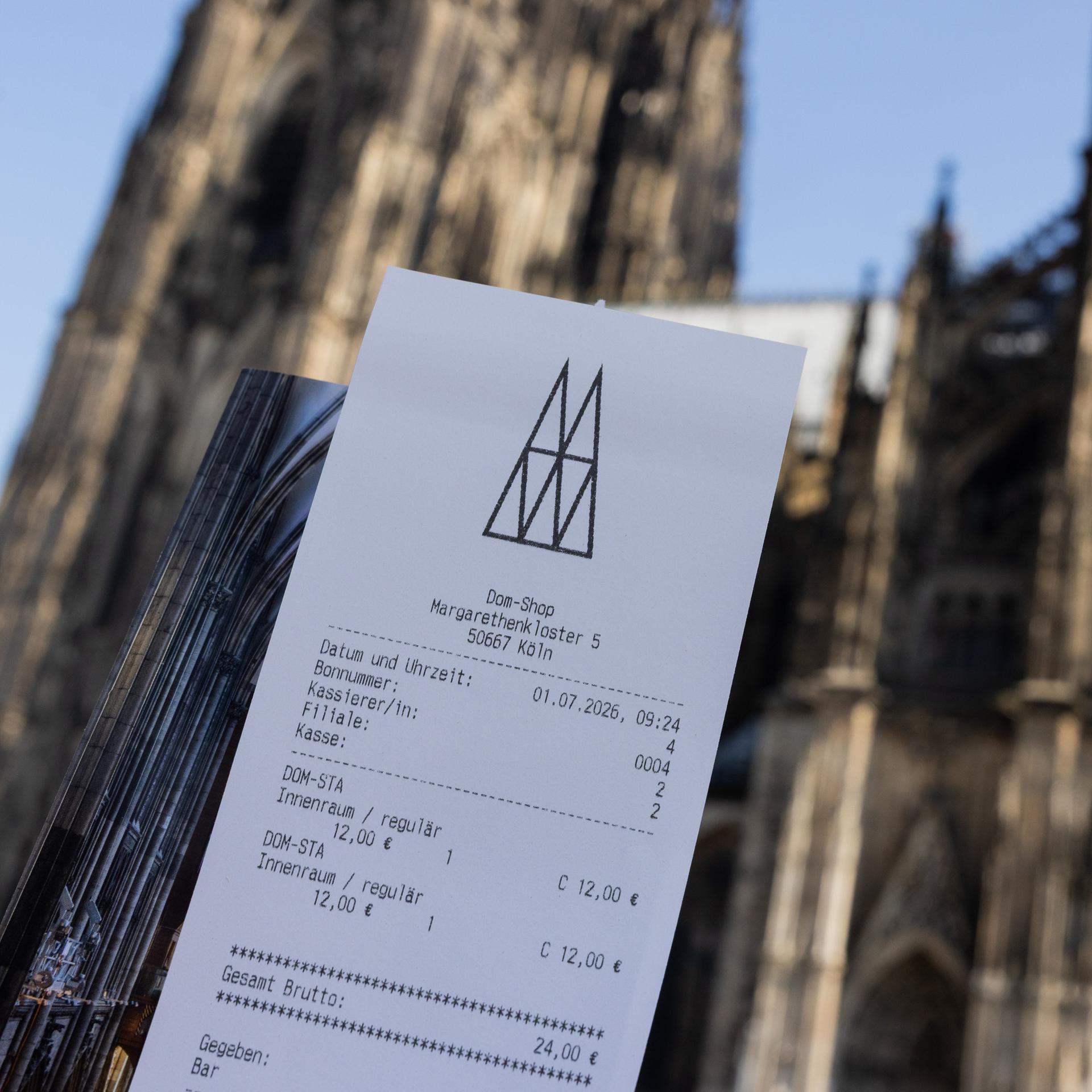 Eine Touristin zeigt ihr Ticket vor dem Kölner Dom. 