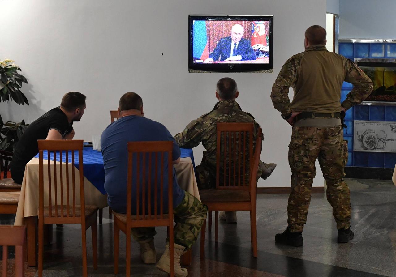 Soldaten sehen sich eine Fernsehansprache des russischen Präsidenten Putin an.