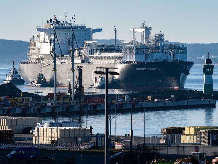 Ein fast 300 Meter langes Schiff läuft begleitet von Schleppern als schwimmendes Energie-Terminal "Deutsche Ostsee" in den Hafen Mukran auf Rügen ein.