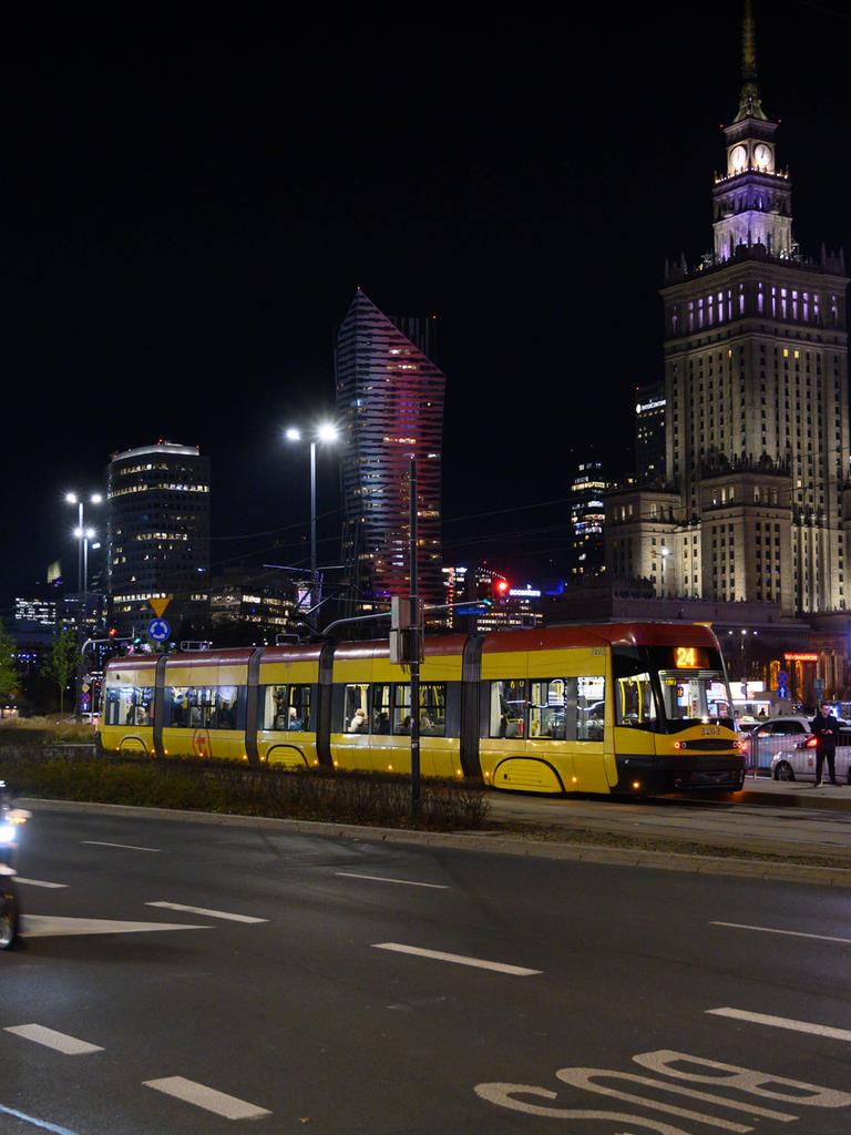 Nächtliches Leben in Warschau. Blick auf den Kulturpalast, umgeben von Wolkenkratzern