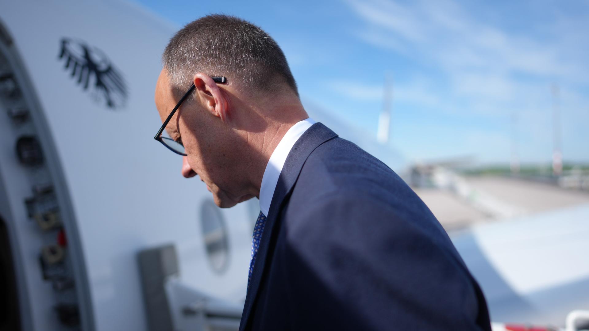 Bundeskanzler Merz steigt in das Flugzeug der Flugbereitschaft. Er reist zu Antrittsbesuchen nach Paris und Warschau.