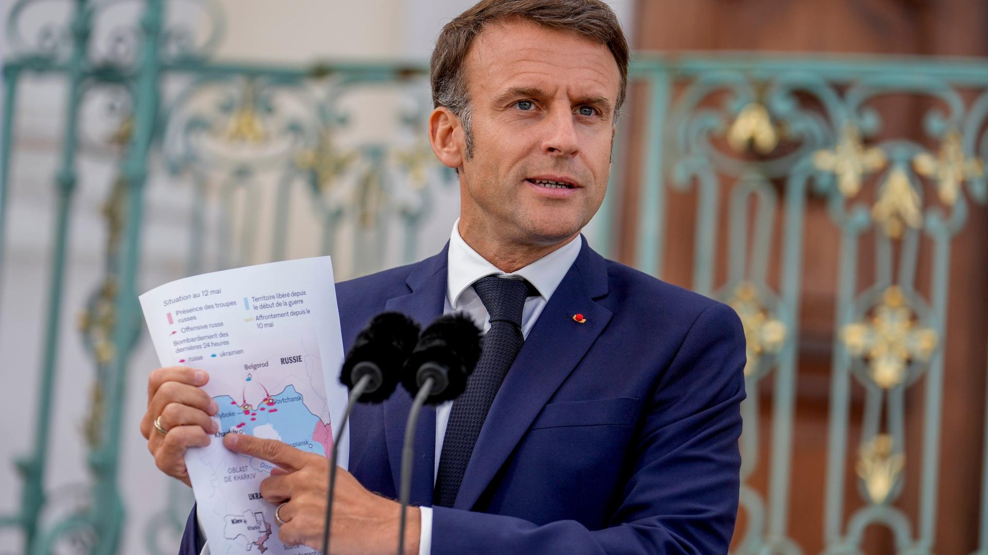 Frankreichs Präsident Emmanuel Macron zeigt während einer Pressekonferenz auf Schloss Meseberg eine Karte der Ukraine und Russland. 