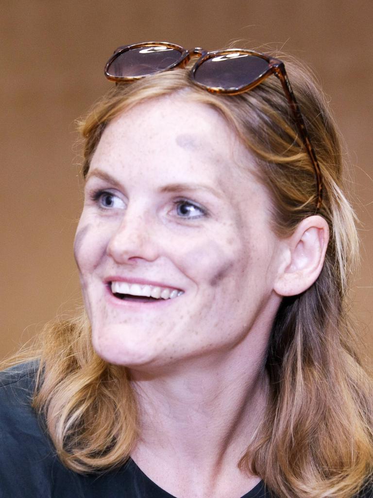 Eine Frau Anfang 30 im Porträt: Cey Leonard hat lange Haare, hat eine Sonnenbrille ins Haar gesteckt und schwarze Streifen auf die Wangen gemalt.