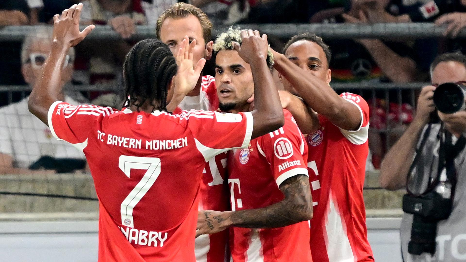 Das Bild zeigt Luis Díaz beim Torjubel, während er von Münchener Mitspielern umringt wird. 