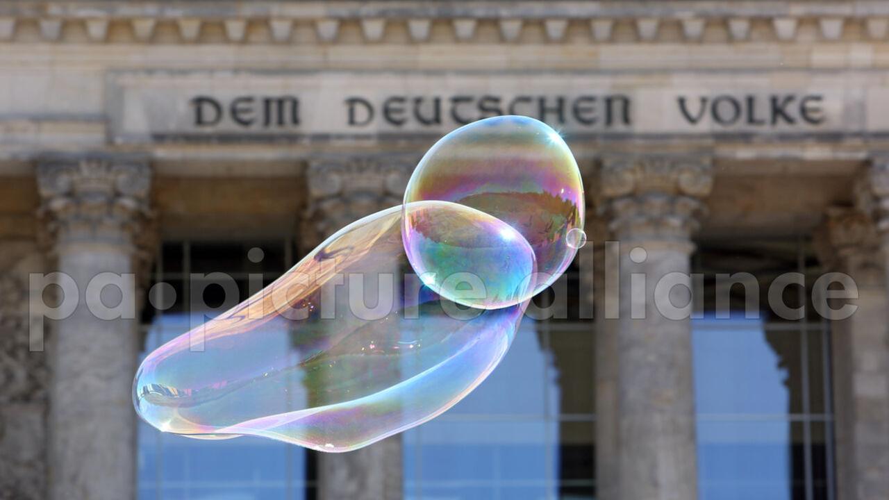 Seifenblasen schweben vor dem Reichstagsgebäude.