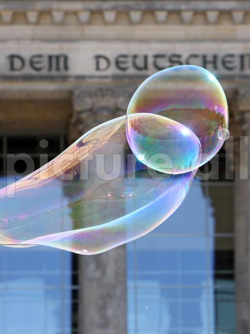 Seifenblasen schweben vor dem Reichstagsgebäude.