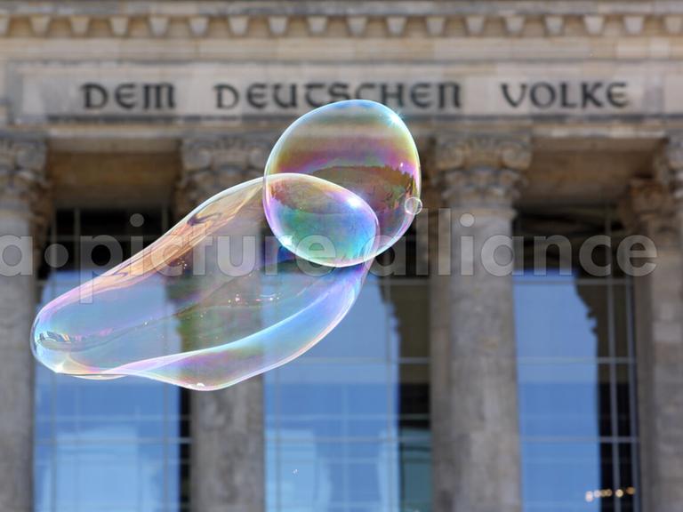 Seifenblasen schweben vor dem Reichstagsgebäude.