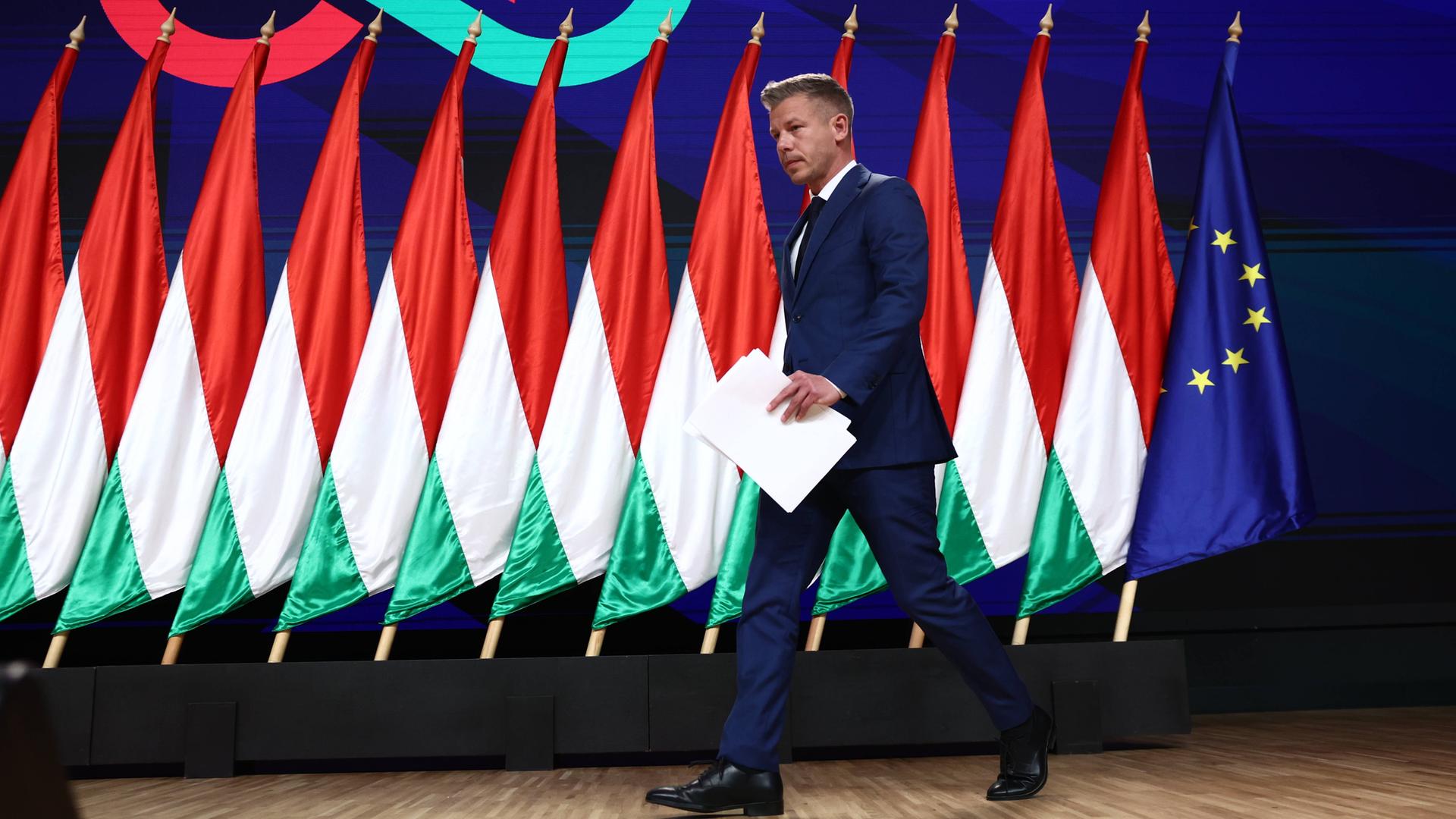 Péter Magyar tritt auf eine mit ungarischen sowie einer EU-Flagge geschmückte Bühne.