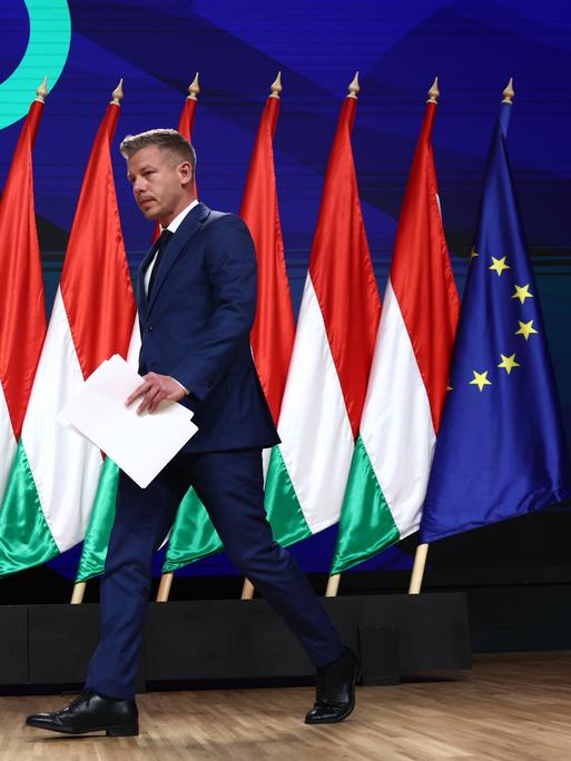 Péter Magyar tritt auf eine mit ungarischen sowie einer EU-Flagge geschmückte Bühne.