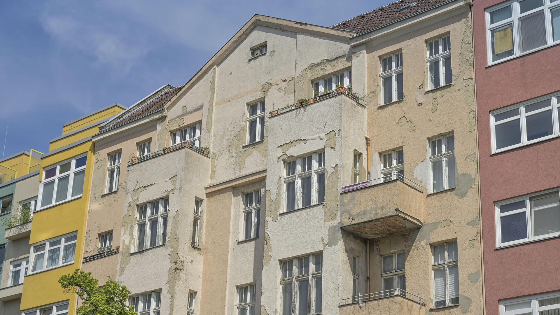 Ein verfallenes Haus zwischen renovierten Häusern
