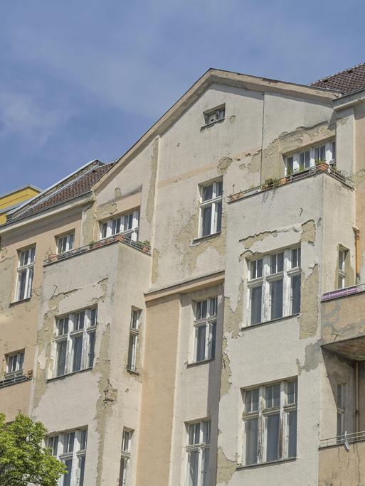 Ein verfallenes Haus zwischen renovierten Häusern