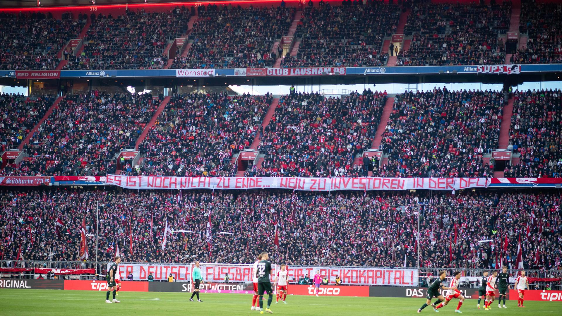 In der Fankurve des FC Bayern werden Protestplakate mit Sprüchen gegen die Investorenpläne der DFL gezeigt - darunter "Es ist noch nicht zu Ende - Nein zu Investoren in der DFL". In der Fankurve des FC Bayern werden Protestplakate mit Sprüchen gegen die Investorenpläne der DFL gezeigt - darunter "Es ist noch nicht zu Ende - Nein zu Investoren in der DFL".