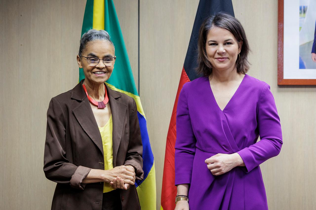 Bundesaußenministerin Annalena Baerbock (Buendnis 90/Die Gruenen) steht neben der brasilianischen Umweltministerin Marina Silva. Im Hntergrund sind die brasilianische und die deutsche Flagge zu sehen. 