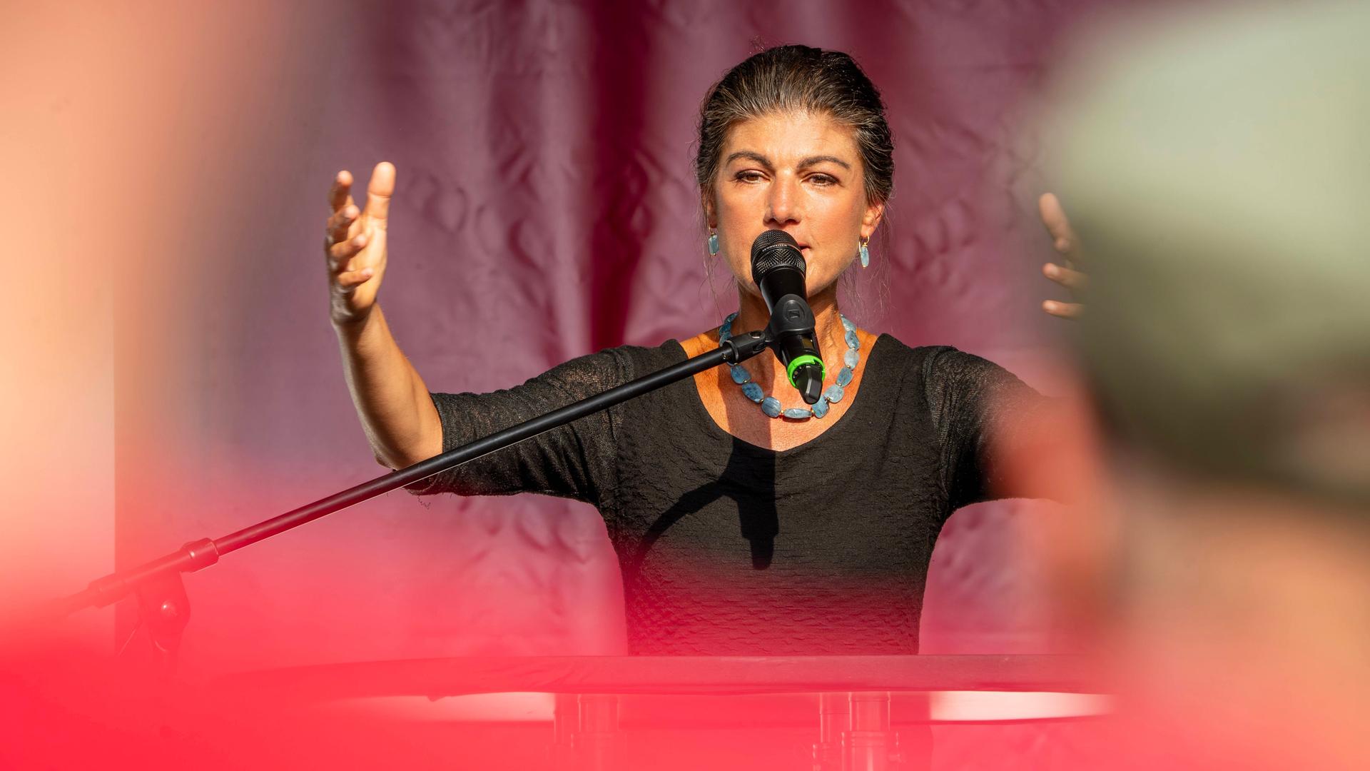 Sahra Wagenknecht spricht bei einem Wahlkampfauftritt mit gehobener Hand in Altenburg in ein Mikrofon.