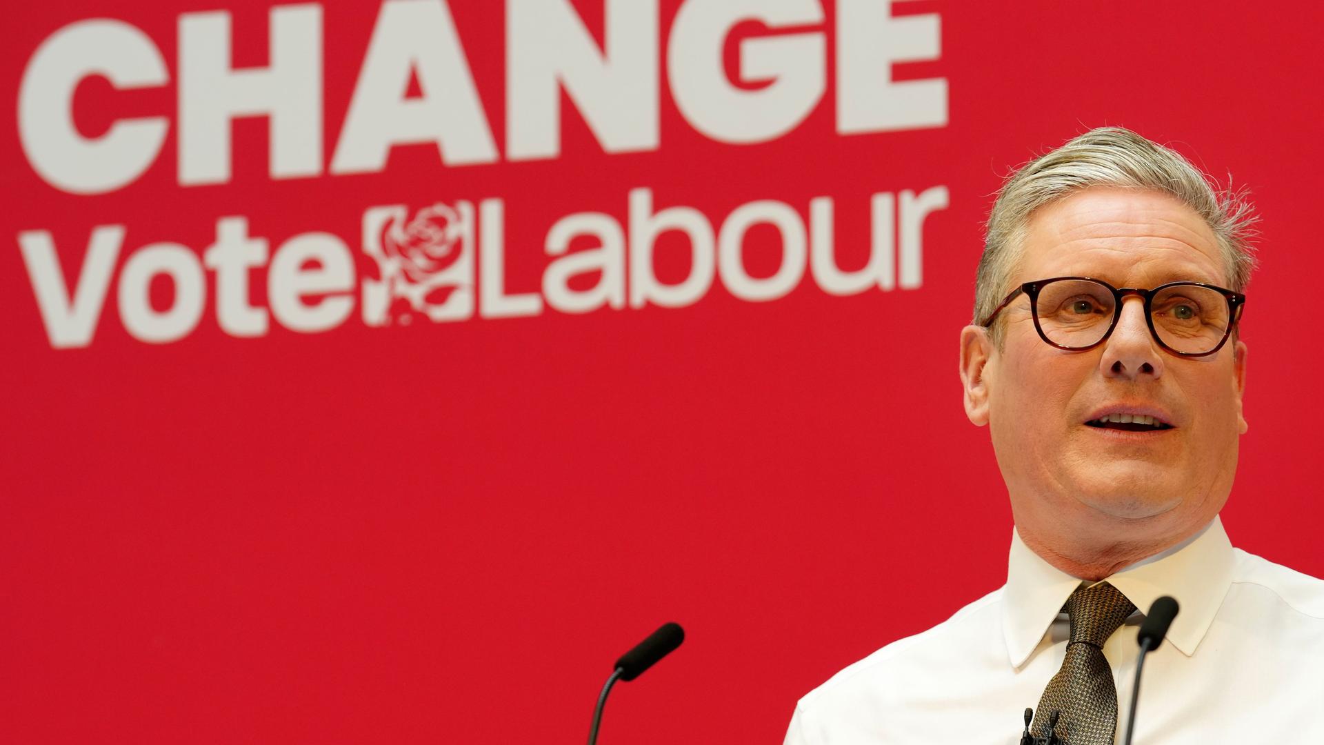 Der Labour-Vorsitzende Keir Starmer steht an einem Mikrofon und redet. Im Hintergrund ist das Logo seiner Partei zu sehen und der Schriftzug "Wandel". Der Labour-Vorsitzende Keir Starmer steht an einem Mikrofon und redet. Im Hintergrund ist das Logo seiner Partei zu sehen und der Schriftzug "Wandel".