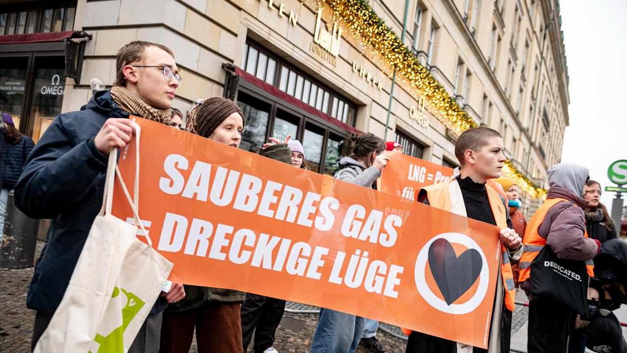 Demonstranten der Letzten Generation stehen vor dem Hotel Adlon in Berlin mit einem Schild mit der Aufschrift "Sauberes Gas = dreckige Lüge". 