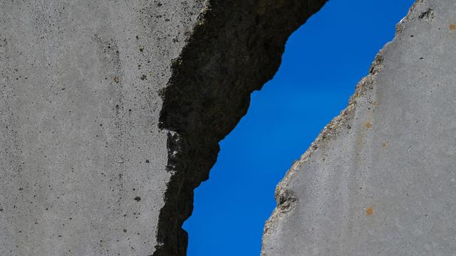 Breiter Riss in einer Mauer mit blauem Himmel im Hintergrund Breiter Riss in einer Mauer mit blauem Himmel im Hintergrund