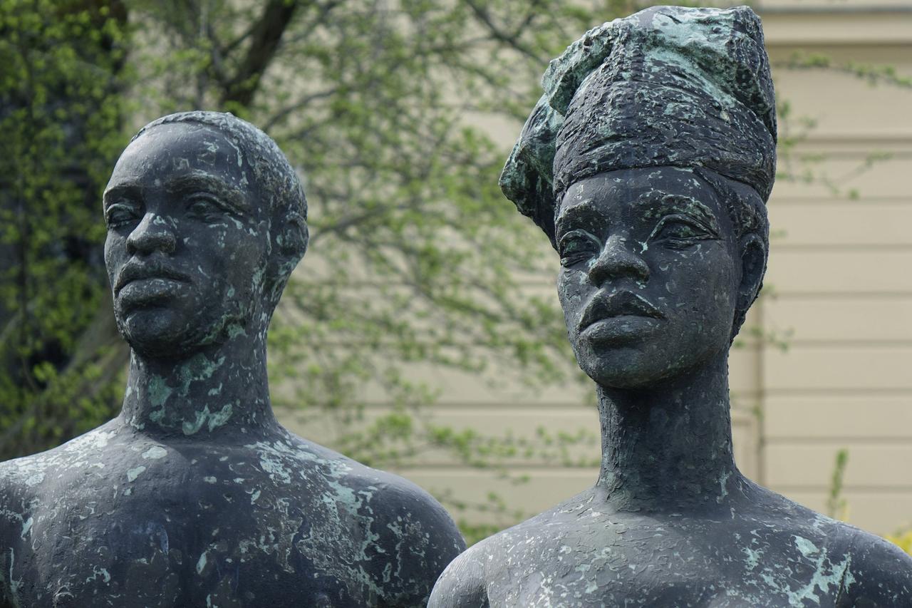 Die Bronzeplastik "Freies Afrika" zeigt die stereotype Darstellung eines Schwarzen Mannes im Lendenschurz und einer Schwarzen Frau in Kleid und Kopfwickel.