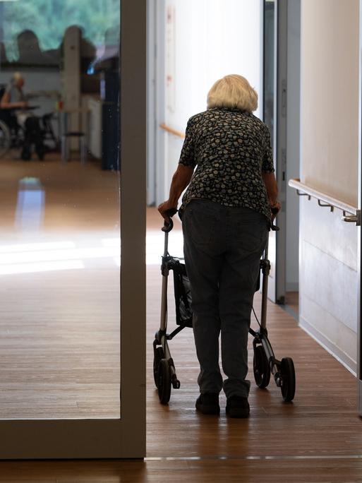 Eine Seniorin mit Rollator geht einen Korridor in einem Pflegeheim entlang, Symbolfoto.