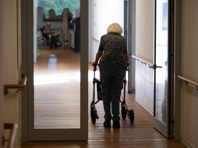 Eine Seniorin mit Rollator geht einen Korridor in einem Pflegeheim entlang, Symbolfoto.