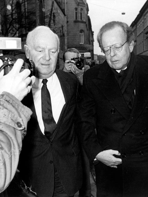 Am 06.03.1986 wird der frühere Konzernchef Friedrich Karl Flick am Bonner Landgericht in der Parteispenden-Affäre als Zeuge vernommen. Er steigt aus einem Auto aus. Ein Fotograf macht Fotos von ihm (Archivfoto) Am 06.03.1986 wird der frühere Konzernchef Friedrich Karl Flick am Bonner Landgericht in der Parteispenden-Affäre als Zeuge vernommen. Er steigt aus einem Auto aus. Ein Fotograf macht Fotos von ihm (Archivfoto)
