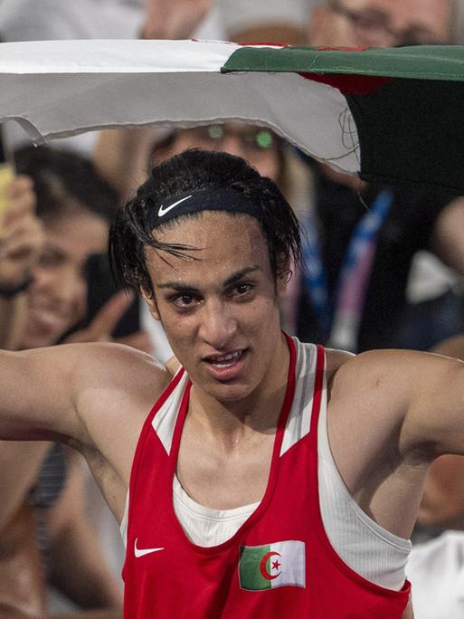 Die algerische Boxerin Imane Khelif feiert mit der Flagge ihres Heimatlands den Gewinn der Goldmedaille im Boxen. 