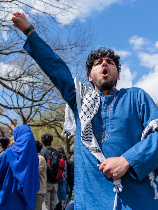 Studierende bei einer Solidaritätskundgebung an der Brown University in Rhode Island am 24.04.2024 mit Palästinensertuch und erhobener Faust.