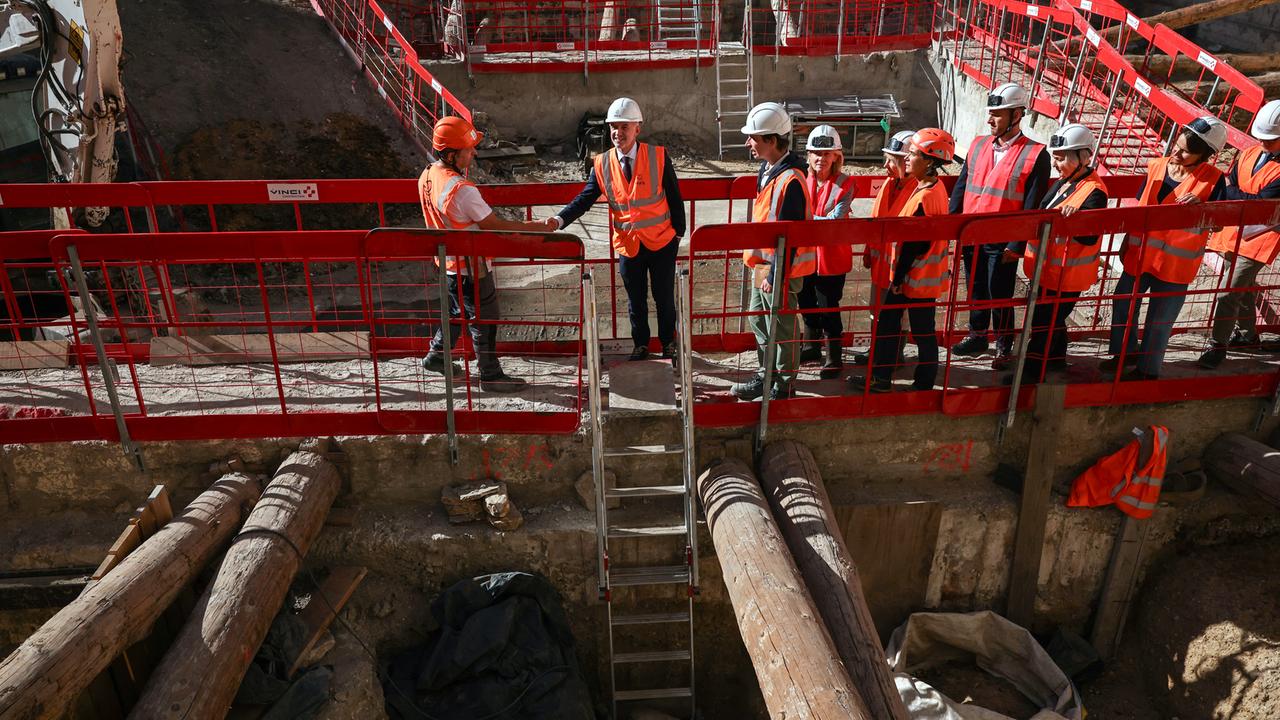 Mehrere Menschen gehen in orangen Westen auf Laufstegen über eine Baustelle in Paris, wo das gallische Lutetia vermutet wird.