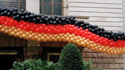 Eine Girlande aus Luftballons in den Farben der deutschen Flagge hängen an einer Hausfassade. Eine Girlande aus Luftballons in den Farben der deutschen Flagge hängen an einer Hausfassade.