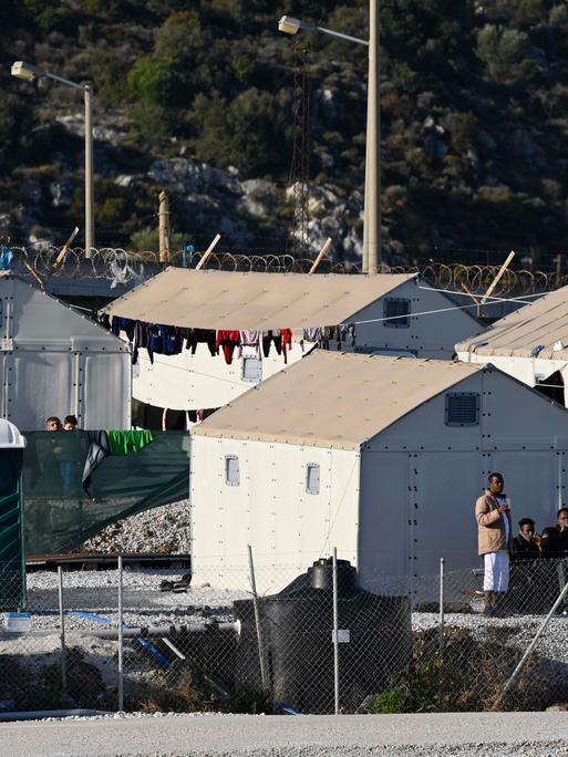 Mehrere provisorische Zelte stehen im Flüchtlingslager Moria auf der griechischen Insel Lesbos, vor einigen stehen Migranten. Mehrere provisorische Zelte stehen im Flüchtlingslager Moria auf der griechischen Insel Lesbos, vor einigen stehen Migranten.